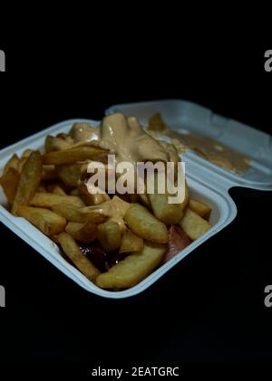 currywurst mit Pommes in eine Tasse. Traditionelles deutsches Essen mit Dip zu Corona Zeiten, negativer Raum zu gehen Stockfoto