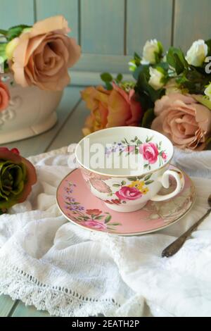 Porzellan Vintage Tee Tasse über Holztisch mit Rosen Stockfoto
