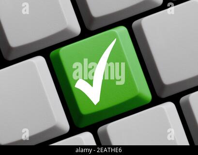 Weißes Häkchen auf der grünen Computertastatur Stockfoto
