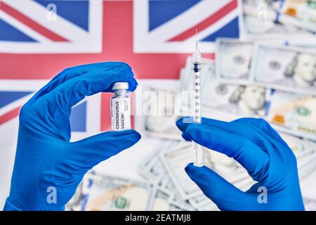 Forscher Hand in blauen Handschuhen mit Coronavirus, covid-19-Impfstoff vor dem Hintergrund der Flagge Englands und Geldkrankheit Vorbereitung für menschliche clini Stockfoto