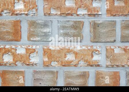 Ein Hintergrund einer verwitterten alten Backsteinmauer im Sonnenschein. Stockfoto