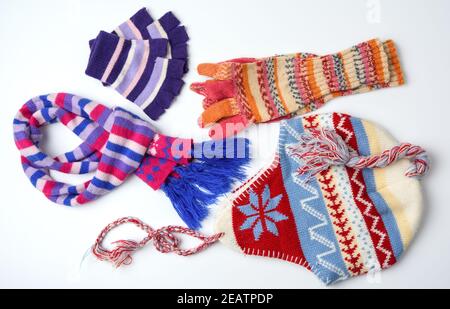Winterhut, Fäustlinge und bunt gestrickter Schal auf weißem Hintergrund Stockfoto