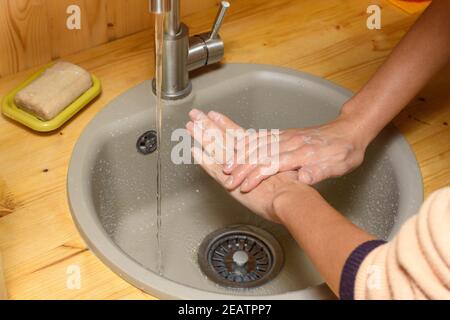 Die Hände des Mädchens waschen gründlich ihre Hände mit Seife ein Das Spülbecken in der Küche Stockfoto