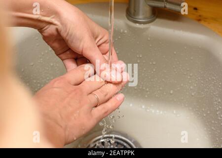 Mädchen Hände unter fließendem Wasser aus dem Wasserhahn in der Waschbecken Stockfoto