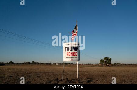 Ein Landwirt außerhalb von Smithville im Bastrop County, TX, fliegt drei Monate nach der Novemberwahl, bei der die republikanische Karte verloren hat, eine leicht zerfetzte amerikanische Flagge über einem Trump-Pence-Wahlkampfschild. Meinungsumfragen zeigen, dass sich viele Texaner im ländlichen Raum immer noch weigern, einen demokratischen Präsidentschaftssieg zu akzeptieren. ©Bob Daemmrich Stockfoto