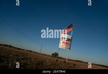 Ein Landwirt außerhalb von Smithville im Bastrop County, TX, fliegt drei Monate nach der Novemberwahl, bei der die republikanische Karte verloren hat, eine leicht zerfetzte amerikanische Flagge über einem Trump-Pence-Wahlkampfschild. Meinungsumfragen zeigen, dass sich viele Texaner im ländlichen Raum immer noch weigern, einen demokratischen Präsidentschaftssieg zu akzeptieren. ©Bob Daemmrich Stockfoto