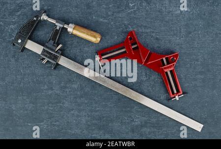 Zwei Schraubklemmen aus Metall, Nahaufnahme auf grauem Hintergrund, Draufsicht Stockfoto