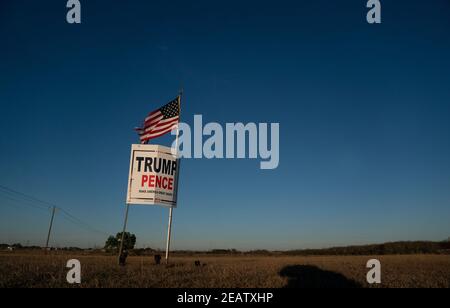 Smithville, Texas, USA. Februar 2021, 2nd. Ein Landwirt außerhalb von Smithville im Bastrop County, TX, fliegt drei Monate nach der Novemberwahl, wo das republikanische Ticket verloren hat, eine leicht zerfetzte amerikanische Flagge über einem Trump-Pence-Wahlkampfschild. Viele ländliche Texaner weigern sich immer noch, einen demokratischen Sieg zu akzeptieren. Quelle: Bob Daemmrich/ZUMA Wire/Alamy Live News Stockfoto