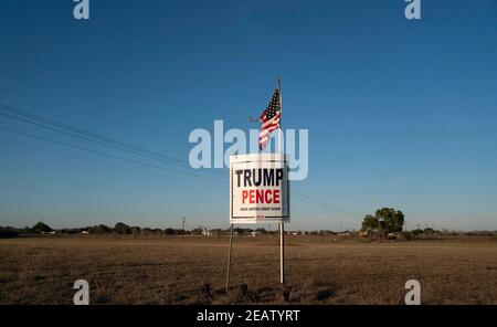 Smithville, Texas, USA. Februar 2021, 2nd. Ein Landwirt außerhalb von Smithville im Bastrop County, TX, fliegt drei Monate nach der Novemberwahl, wo das republikanische Ticket verloren hat, eine leicht zerfetzte amerikanische Flagge über einem Trump-Pence-Wahlkampfschild. Viele ländliche Texaner weigern sich immer noch, einen demokratischen Sieg zu akzeptieren. Quelle: Bob Daemmrich/ZUMA Wire/Alamy Live News Stockfoto