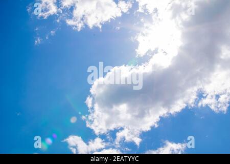 Cumulus Wolken am blauen Himmel und Sonnenstrahlen brechen durch die Wolken. Speicherplatz kopieren Stockfoto