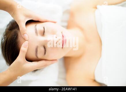 Entspannte junge Frau genießen Massage im Spa-Salon Stockfoto