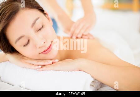 Entspannte junge Frau genießen Massage im Spa-Salon Stockfoto