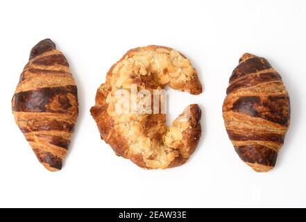 Gebackenes Croissant mit Mandeln bestreut, Dessert isoliert auf weißem Hintergrund, Set Stockfoto