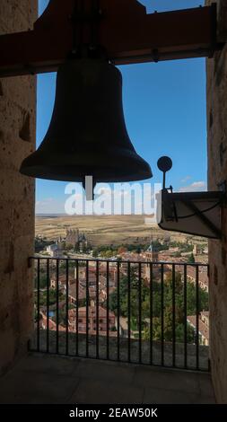 Glockenturm der Kathedrale von Segovia in Spanien mit Segovia Schloss in der Ferne Stockfoto