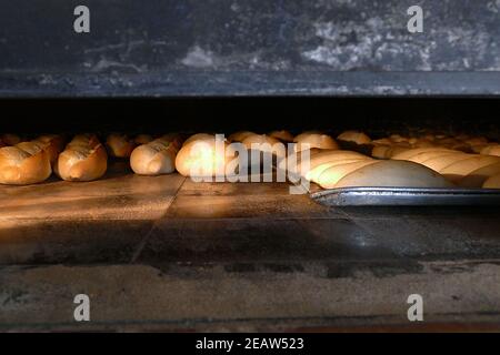 Ein großer klassischer Holzofen, der Brot, Holzofen und gebackenes Brot backt Stockfoto