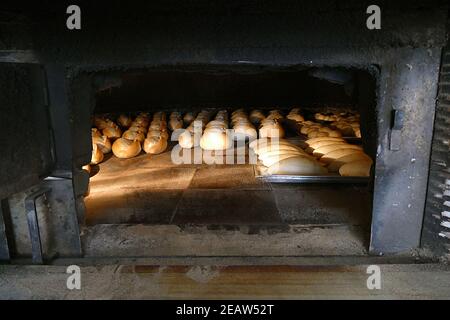 Ein großer klassischer Holzofen, der Brot, Holzofen und gebackenes Brot backt Stockfoto