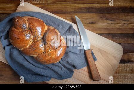 Ein Laib Weißbrot und ein Messer auf dem Küchenbrett Stockfoto