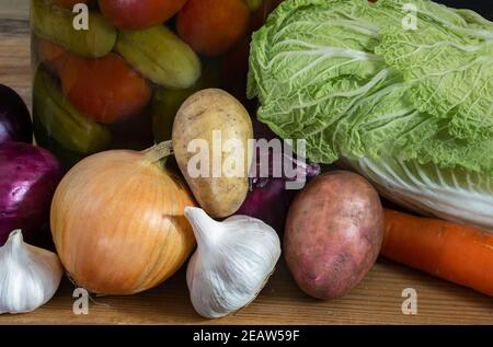 Konserven und frisches Gemüse auf einem Holzregal Stockfoto
