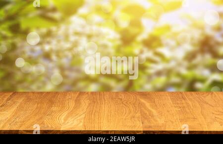Leerer Holztisch auf natürlichem Grün verschwommener Hintergrund Stockfoto