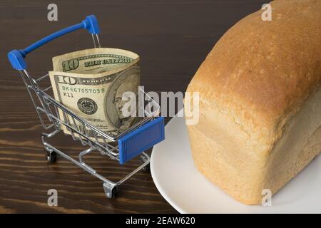 10 Dollar in einem Lebensmittelkorb mit Brot. Steigende Lebensmittelpreise und Lebensmittel in den USA Amerika und anderen Ländern. Humanitäre Hilfe Stockfoto