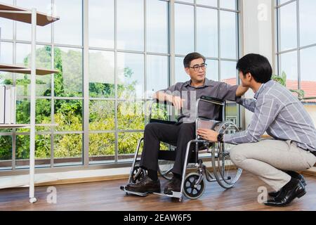 Alter Mann im Rollstuhl und sein kleiner Sohn Stockfoto