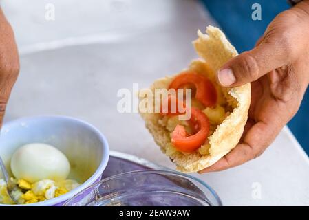 Mann Beim Frühstück Zu Hause. Ein einfaches, gesundes und leckeres Essen.Frische Pita gefüllt mit Ei und Tomaten und ein Gewürz von Olivenöl.echte Menschen.Keine gefiltert. Stockfoto