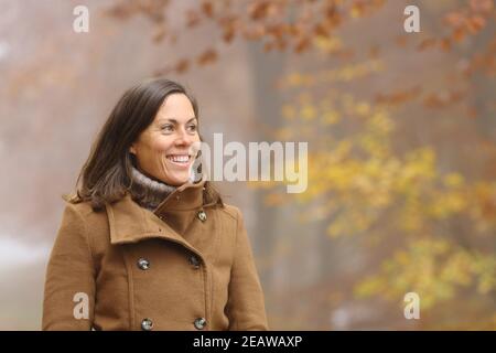 Glückliche Erwachsene Dame erwägt Spaziergänge in einem Park im Herbst Stockfoto