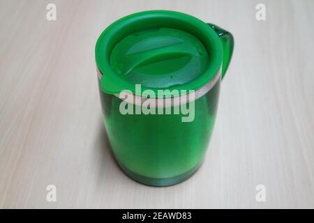 Nahaufnahme einer Tasse auf weißem Schreibtisch. Stockfoto