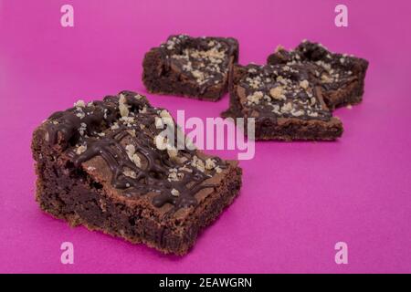 Selektive Fokusaufnahme von leckeren Schokoladen-Brownies auf rosa Hintergrund Stockfoto