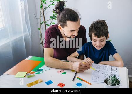 Autistischer Junge während der Therapie zu Hause mit seinem Vater mit Lernen und Spaß zusammen. Autismus-Bewusstsein-Konzept Stockfoto