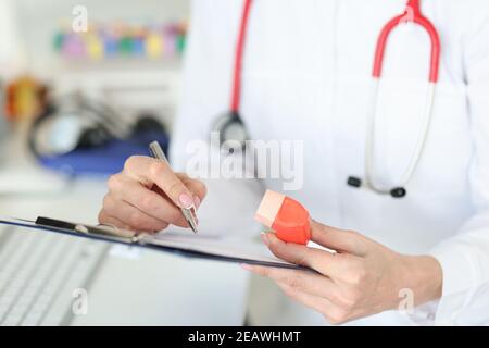 Pneumologe hält Inhalator in den Händen und schriftlich in Dokumenten Nahaufnahme Stockfoto