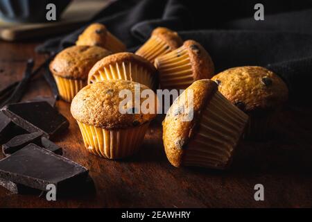 VanilleMuffins. Süße Cupcakes mit Schokolade und Vanilleschoten auf Holztisch. Stockfoto