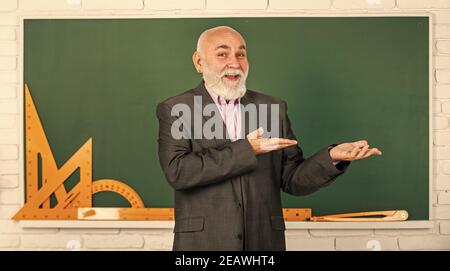 Präsentation Produkt. Holen Sie sich Wissen hier. Senior Mann Lehrer verwenden mathematische Werkzeuge. Bärtigen Dozent Mann erklären Geometrie auf Tafel. Zurück zur Schule. Mathematische grafische Werkzeuge. trigonometrie Unterricht im Klassenzimmer. Stockfoto