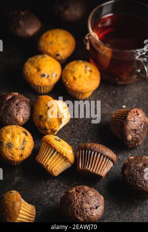 Muffins mit Schokolade und Vanille. Süße Cupcakes auf schwarzem Tisch. Stockfoto