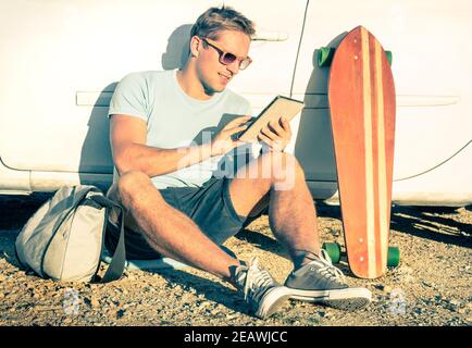 Junger Hipster Mann mit Tablet neben seinem Auto sitzen - Konzept der modernen Technologien gemischt mit einem Vintage-Lifestyle - Retro-Look mit Filter Stockfoto