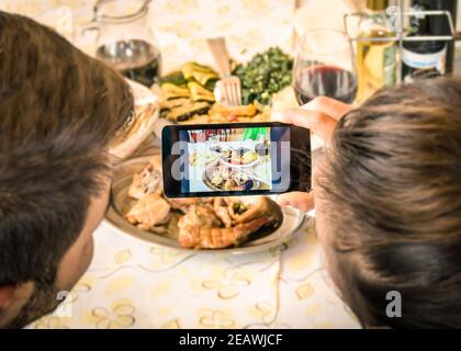 Ein Paar von Freund und Freundin nehmen ein Essen Selfie in Dinner Restaurant - Moda der Fang der Instant mit modernen Smartphone zum Mittagessen Stockfoto