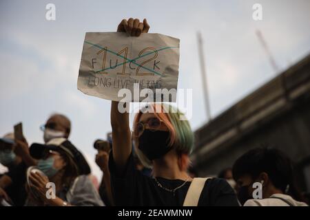 Bangkok, Thailand. Februar 2020, 10th. (ANMERKUNG DER REDAKTION: Bild enthält Obszönität) EIN Protestler hält während der Demonstration ein Plakat.Pro-Demokratie-Demonstranten haben das "Pot hämmern gegen Diktatur"-Ereignis auf dem Skywalk vor dem MBK-Zentrum und auch vor dem Bangkok Art and Culture Center (BACC) eingerichtet. Die Demonstranten forderten den Rücktritt von Thailands Premierminister Prayuth Chan-ocha und Reformen der Monarchie. Nachdem Polizeibeamte 10 Demonstranten unter verschiedenen Anschuldigungen wie der Aufrechterhaltung der öffentlichen Sanitär-und Ordnung Gesetz und die Kontrolle der Armam festgenommen Stockfoto