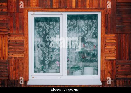 Fenster in einem alten Holzhaus Blick von der Straße Stockfoto