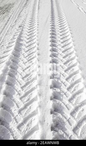 Abbildung der Reifenspuren von schweren Fahrzeugen im Schnee. Stockfoto