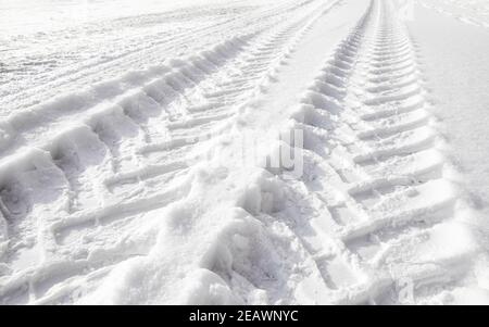 Abbildung der Reifenspuren von schweren Fahrzeugen im Schnee. Stockfoto