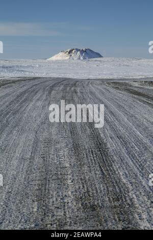 Ein Pingo-Wahrzeichen (Intra-Permafrost-eisbedeckter Hügel) entlang des Kieses Inuvik-Tuktoyaktuk Highway im Winter, Northwest Territories, Kanadas Arktis. Stockfoto