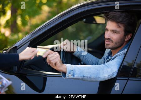Mann, der das Ticket nimmt, um die Kontrolle auf dem Parkplatz zu übernehmen Stockfoto