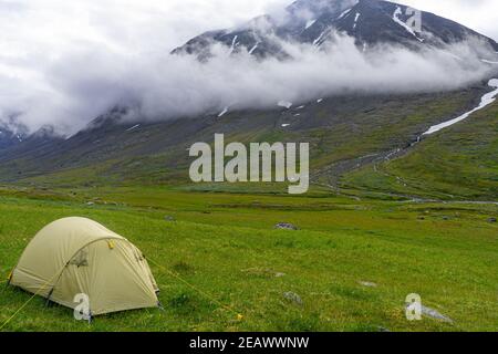 Panorama mit Camping Zelt in der Landschaft des Sarek Nationalparks, Schweden, an einem bewölkten und regnerischen Tag Stockfoto