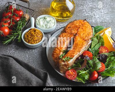Gebratener, gebratener, gebackener Fisch Steak Lachs mit frischem Salat und Tomaten Draufsicht Stockfoto