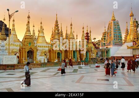 Besucher in der Shwedagon Pagode bei Sonnenuntergang in Yangon, Myanmar Stockfoto