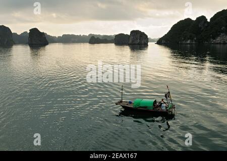 Kleines traditionelles Boot in Bai TU Long bei Sonnenaufgang, Ha Long Bucht, Vietnam Stockfoto