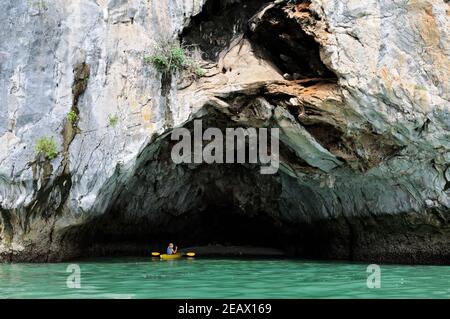 Mann Kajakfahren in einer Höhle in Bai TU Long, Ha Long Bay, Vietnam Stockfoto