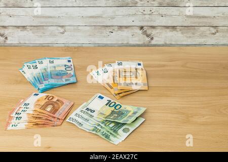 Mehrere Stapel von Euro-Banknoten gruppiert nach dem Wert von zehn Zwanzig fünfundhundert auf einem hölzernen Tisch finanzieren Und Sparkonzept Stockfoto