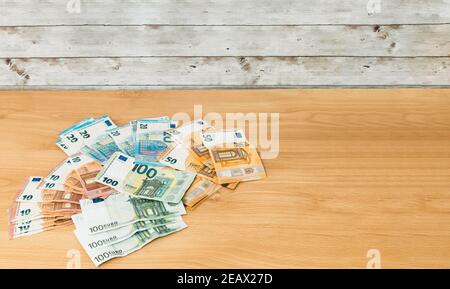 Mehrere europäische Währungsscheine von zehn zwanzig fünfzig und eins Hundert Euro auf einem Holztisch mit Kopieplatz Für finanzielle und Sparzwecke Stockfoto