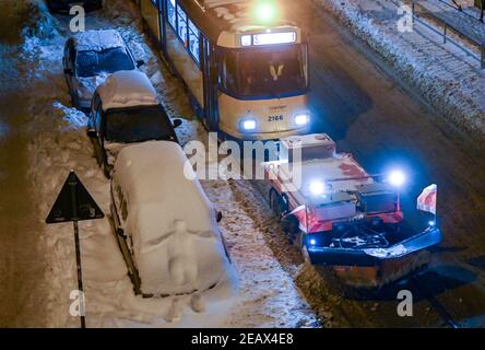 Leipzig, Deutschland. Februar 2021, 11th. Ein spezieller Triebwagen mit Schneepflug räumt die Straßenbahnschienen in Leipzig ab. Ausgedehnte Schneefälle verursachen weiterhin schwere Behinderungen im Straßen- und Schienenverkehr. Quelle: Hendrik Schmidt/dpa-Zentralbild/dpa/Alamy Live News Stockfoto